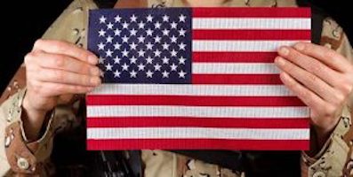 veteran in uniform holding American flag