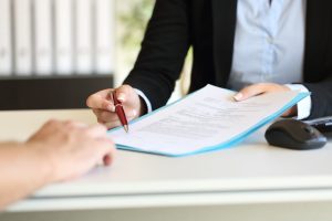 person signing refinance paperwork after divorce